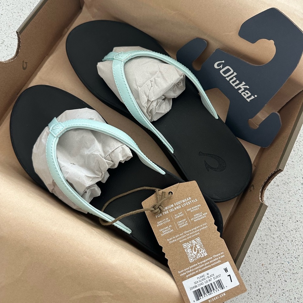 OluKai Pauwe sandal. Size 7/woman. Black & Blue (sea glass). Brand new in box.